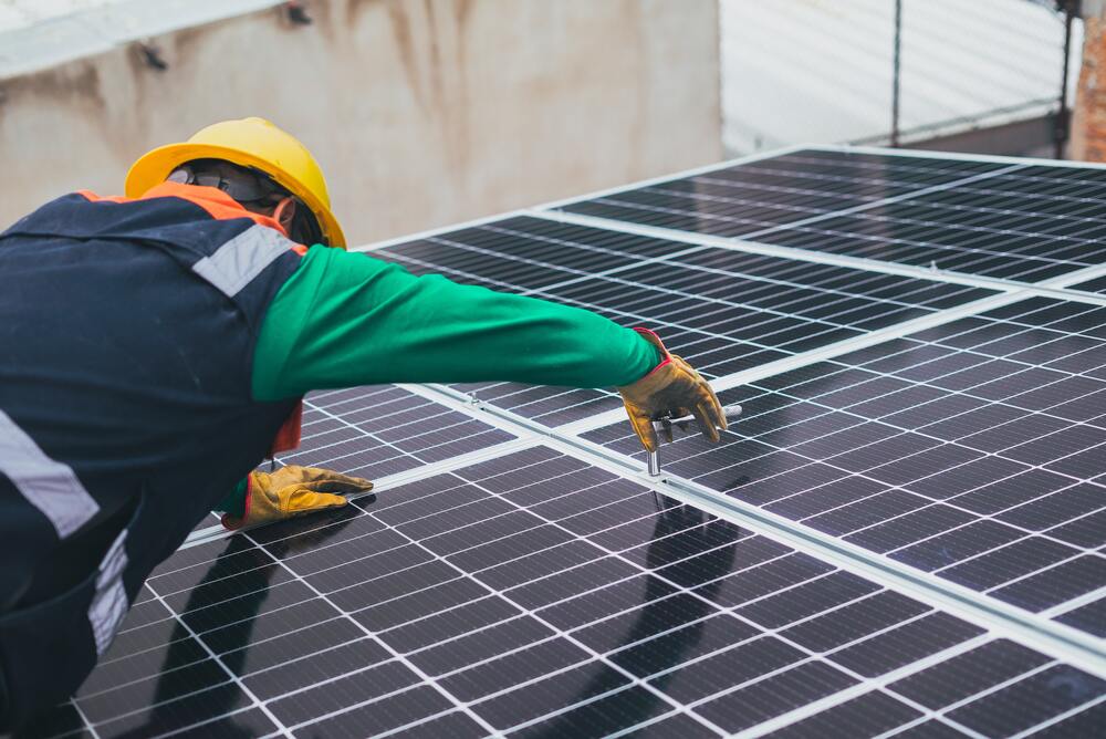 homme installant panneaux solaires